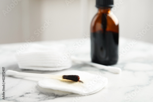 Cotton bud with medical iodine and pad on white marble table, closeup. Space for text