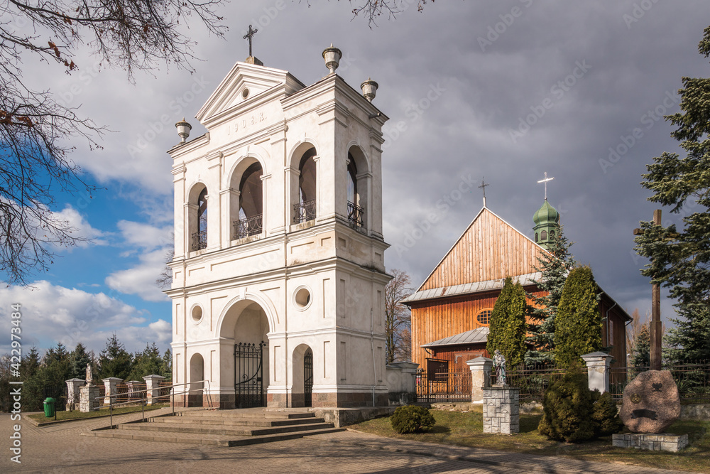 Wooden church and historic brick belfry in Warszawice, Masovia, Poland