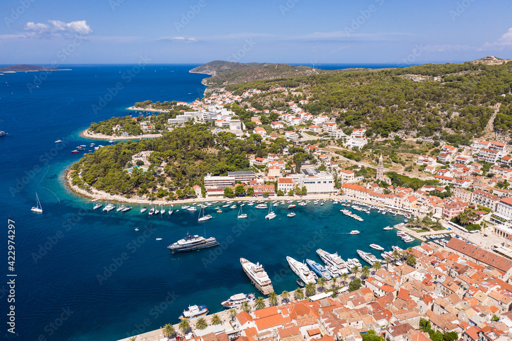 Stunning aerial view of the famous Hvar island and old town with its luxury yachts harbor in Croatia on a sunny summer day