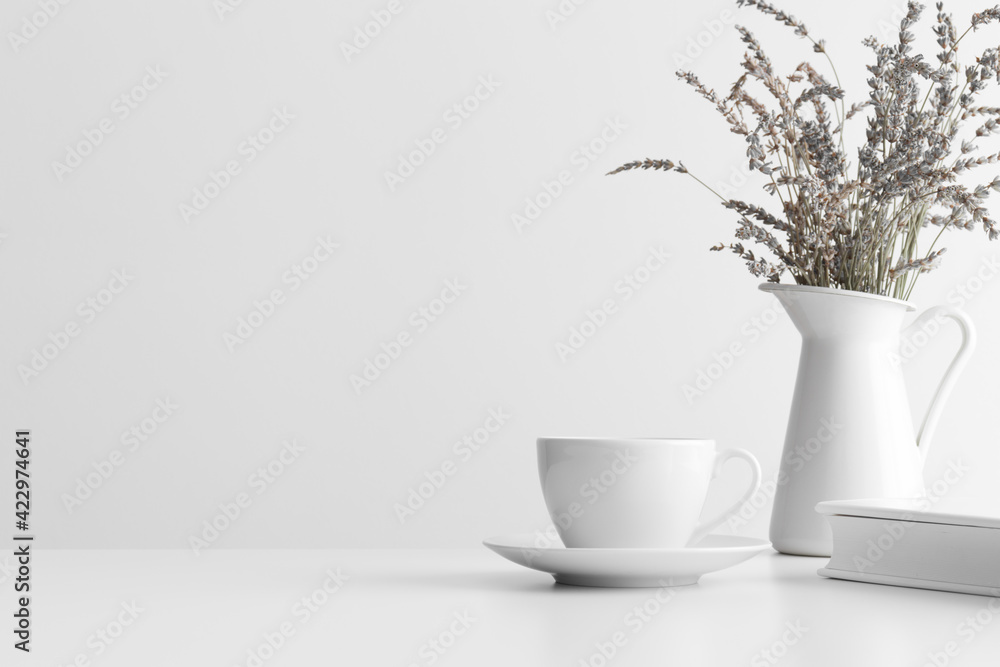 White book, cup of coffee and a lavender in a vase on the white table with blank copy space. White book, cup of coffee and a lavender in a vase on the white table with blank copy space.