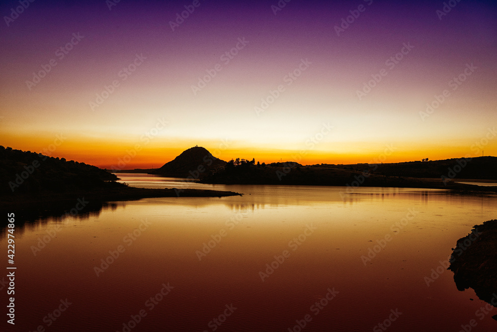 Sunset over the castle lake with golden and red hues