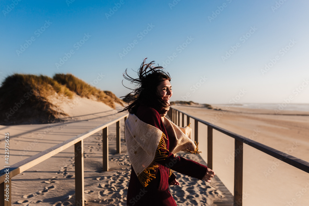 happy woman having fun at the beach on a windy day at sunset. Holidays and fun concept happy woman having fun at the beach on a windy day at sunset. Holidays and fun concept