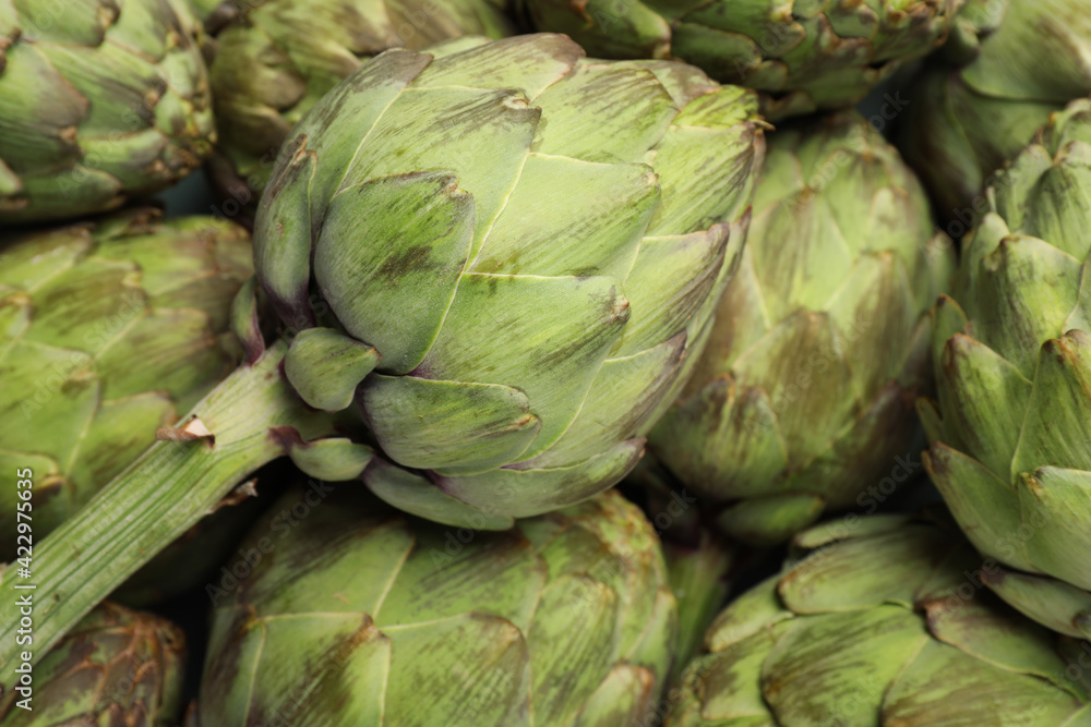 Many fresh raw artichokes as background, closeup Many fresh raw artichokes as background, closeup
