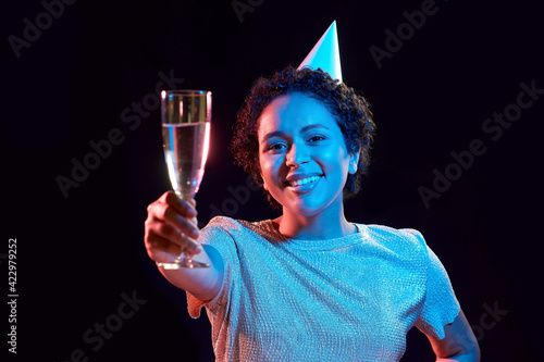 Sticker african woman in party cap with glass of champagne