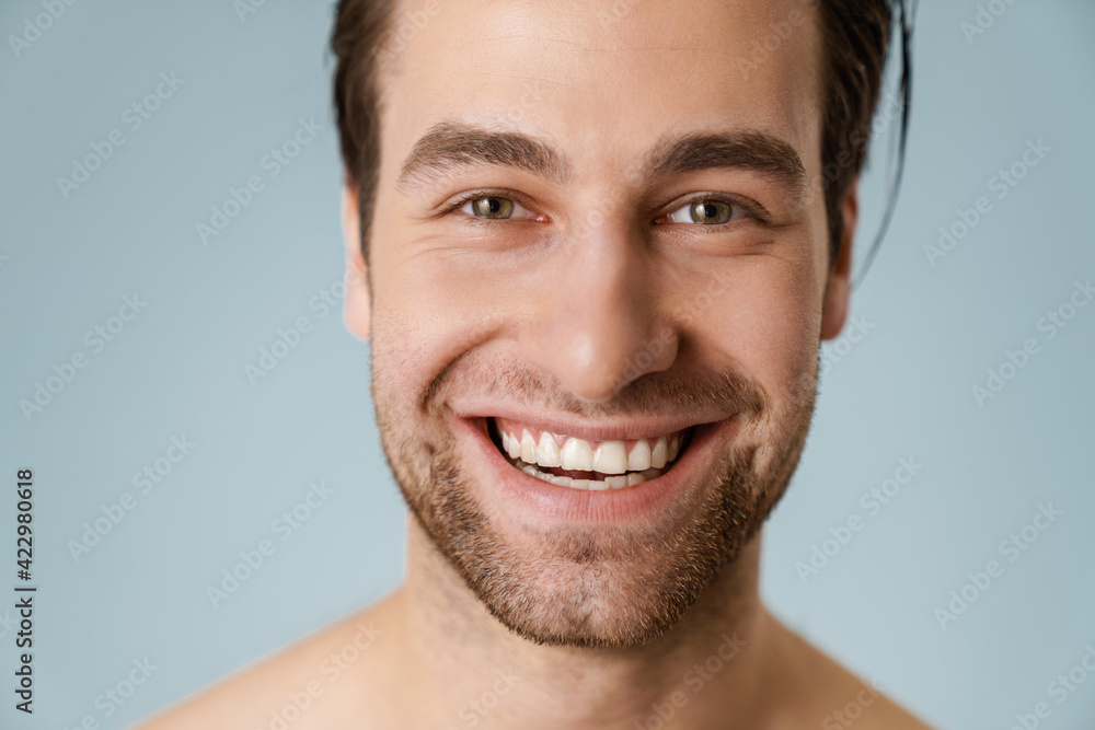 Close up of a smiling brunette shirtless man with stubble Close up of a smiling brunette shirtless man with stubble
