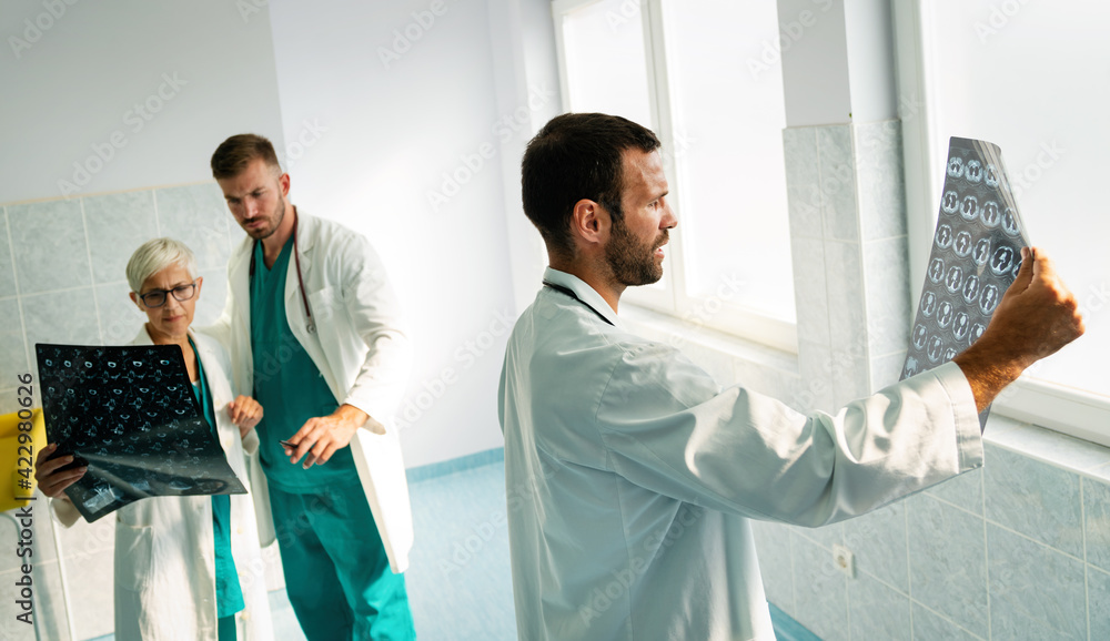 Obraz premium Group of doctor looking at ct scan at hospital to make diagnosis