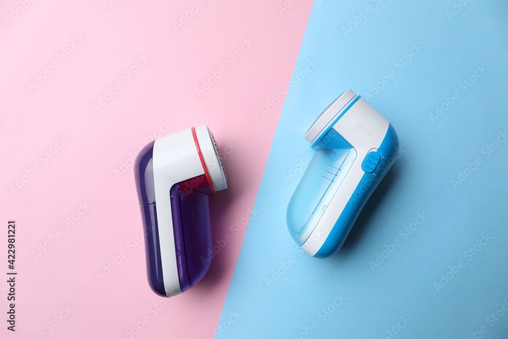 Modern fabric shavers on color background, flat lay Modern fabric shavers on color background, flat lay