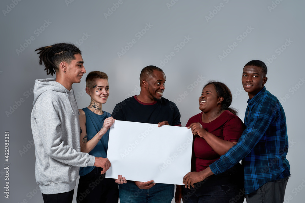 Friendly young multiracial people holding empty banner
