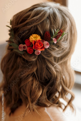 bridesmaid hairstyle in the back with red flowers in her hair
