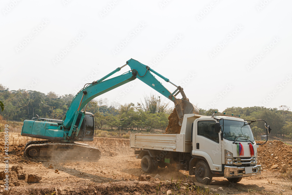 Excavator digging the soil into a truck ,In the construction site area outdoor Excavator digging the soil into a truck ,In the construction site area outdoor