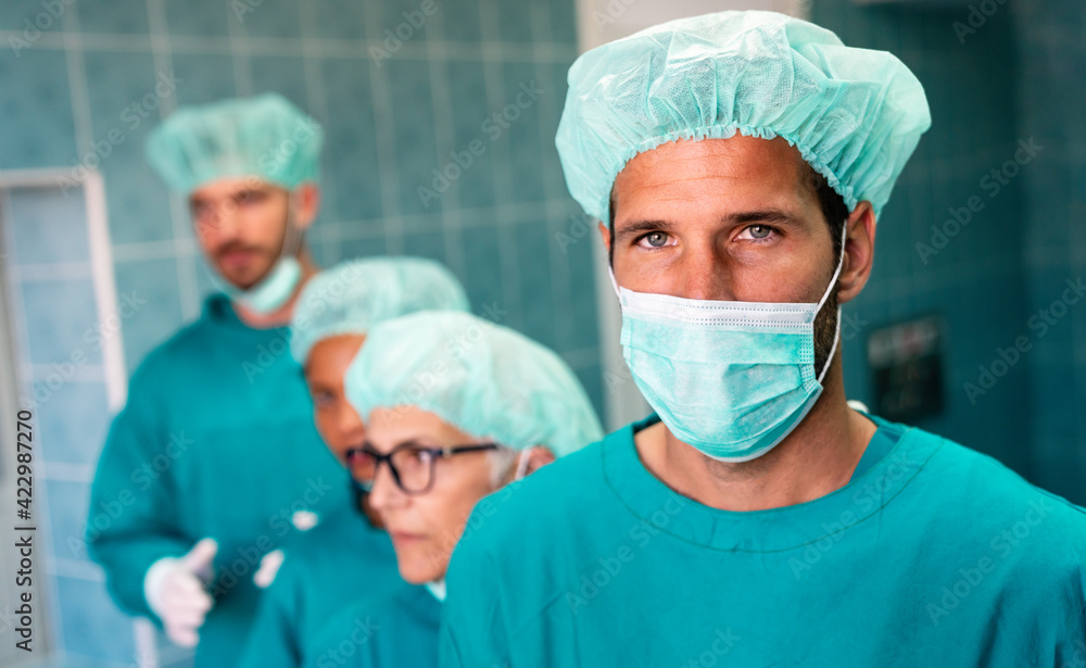 Successful team of surgeon standing in operating room, ready to work on a patient Successful team of surgeon standing in operating room, ready to work on a patient
