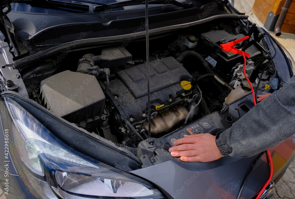 Mechanic hands on open hood. Open hood at service station close-up. Car open bonnet top view Mechanic hands on open hood. Open hood at service station close-up. Car open bonnet top view
