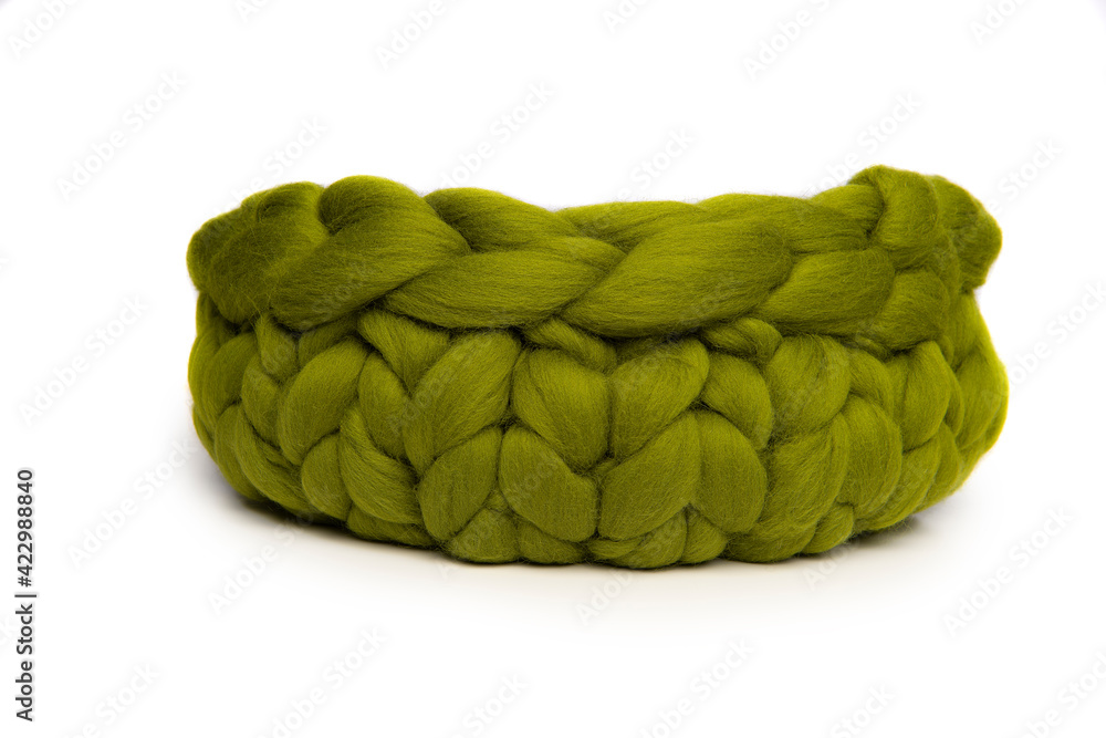 Obraz premium Green woolen animal bed or basket isolated on a white background