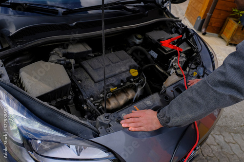 Mechanic hands on open hood. Open hood at service station close-up. Car open bonnet top view