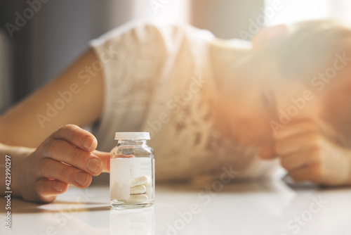 sad depressed young woman reaching for antidepressants. anxiety, fatigue and nervousness