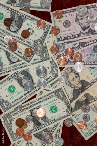 Pile of US dollars and coins on wooden table