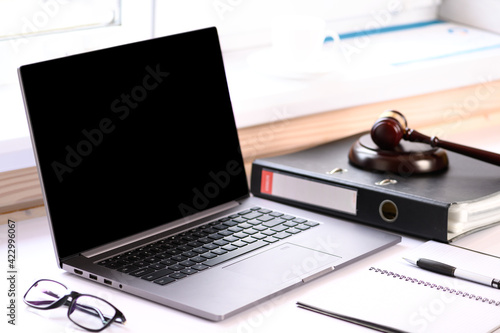 . Jurisprudence courses. On the table there is a computer and a folder with business papers. Online learning