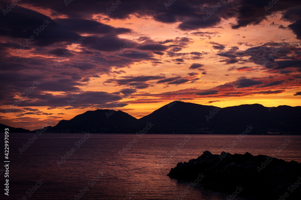 Beautiful sunset in the Gulf of La Spezia view from the small village of Tellaro. On the left the famous town of Porto Venere or Portovenere. Liguria, Italy, Europe.