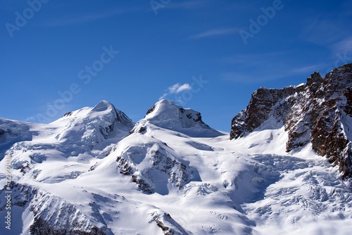 Snow capped mountains  snowfields and glaciers at Zermatt  Switzerland  seen from Gornergrat railway station. Photo taken March 23rd  2021.