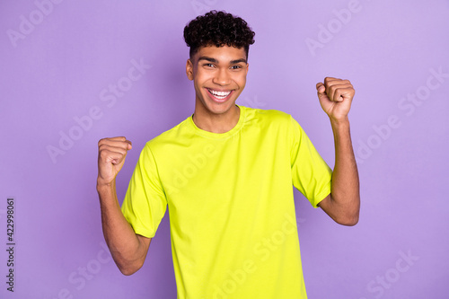 Photo of young excited afro man happy positive smile celebrate win victory fists hands isolated over purple color background