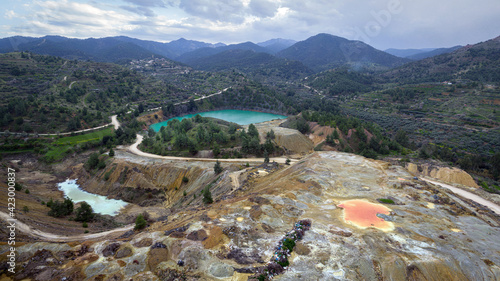 Multicolored waste rocks and tailings from mining near abandoned open pit Memi mine in Xyliatos, Cyprus. This area is rich with copper and sulphide deposits photo