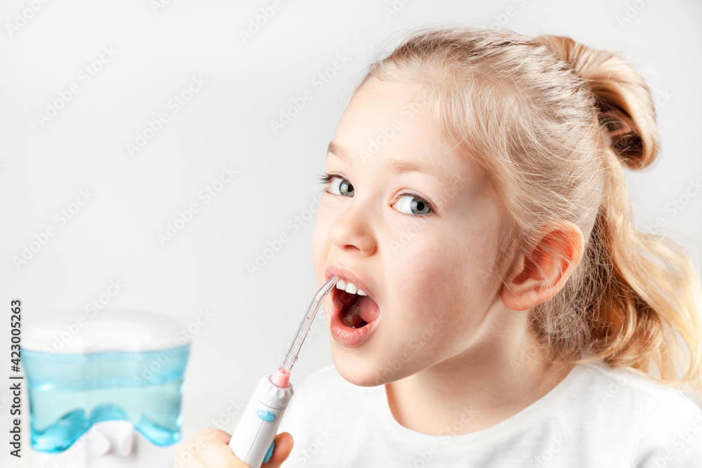Oral irrigator. Child girl brushes her teeth. Prevention of caries. Oral irrigator. Child girl brushes her teeth. Prevention of caries.