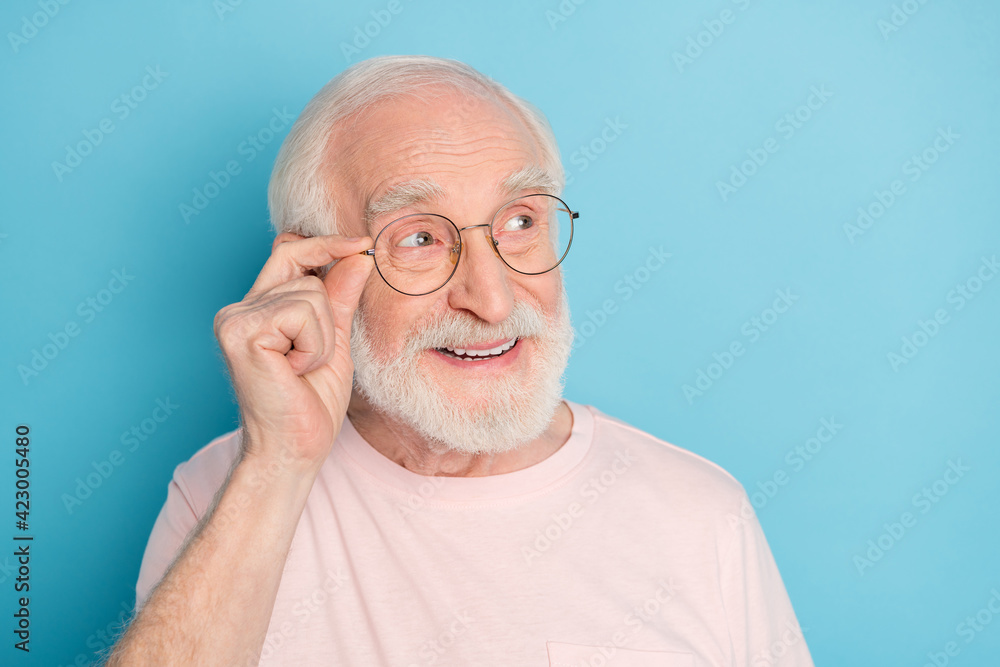 Fototapeta premium Photo of aged man pensioner happy positive smile hand touch glasses look empty space isolated over blue color background