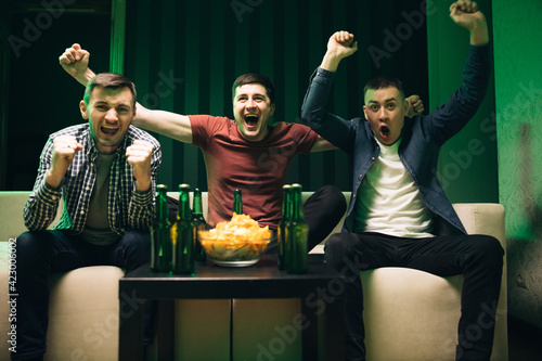 Fotografie Cheerful happy Caucasian guys cheering for favorite team