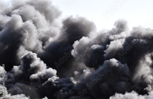 Burning chemical fire in an automobile junkyard with billowing black clouds