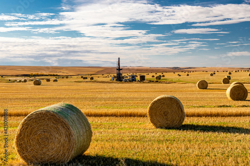 Oil derreck in a hay field surrounded by hay bales. Kneehill County, Alberta, Canada