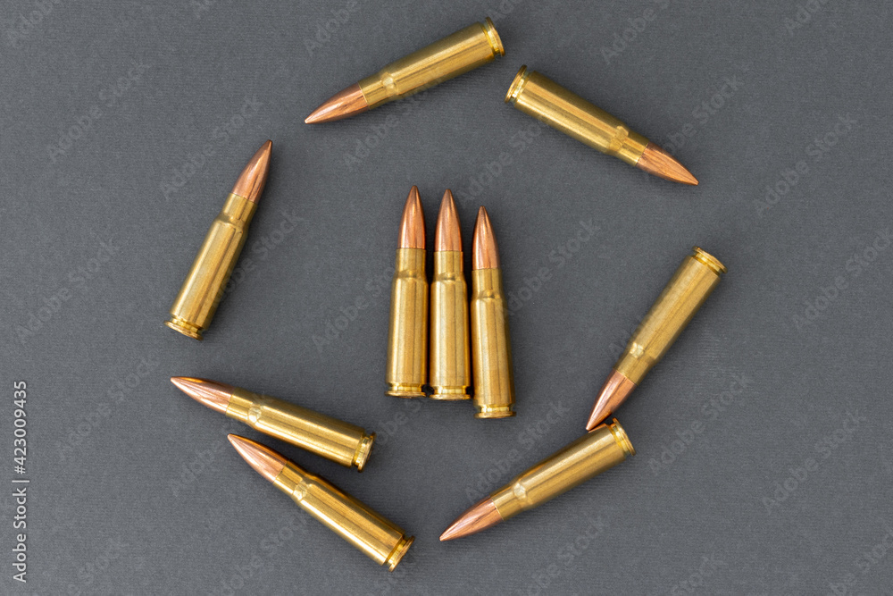 Group of bullets on gray paper background. Cartridges 7.62 caliber for Kalashnikov assault rifle Group of bullets on gray paper background. Cartridges 7.62 caliber for Kalashnikov assault rifle