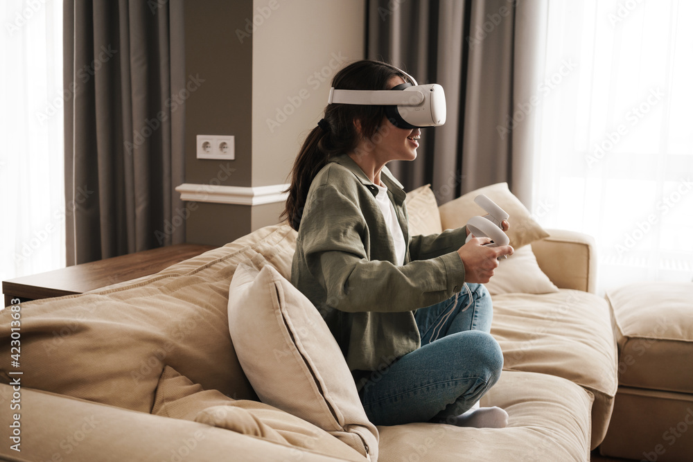 Excite white woman playing online game with vr glasses and controllers