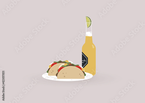 A bottle of cold light beer with a slice of lime inside and two tacos on a plate, a traditional Mexican street food with meat and vegetables