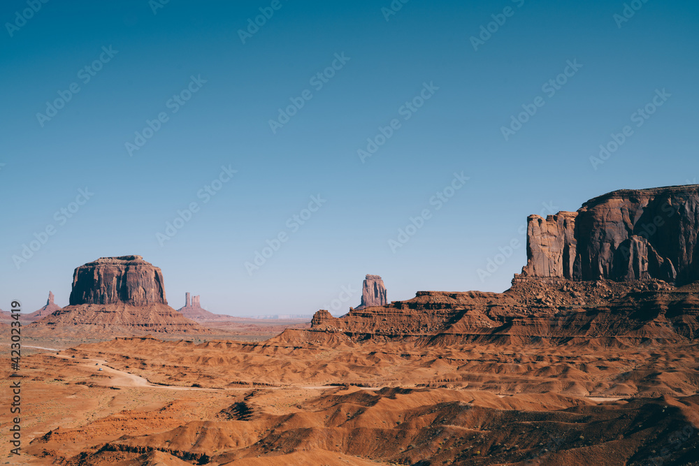Majestic rocks in red sand desert in sunlight Majestic rocks in red sand desert in sunlight