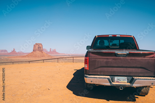 Red pickup truck against high plain and blue sky