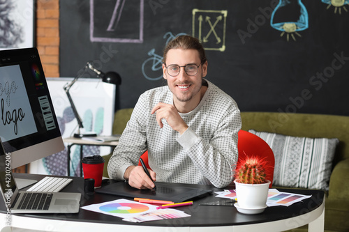 Young male designer working in office photo