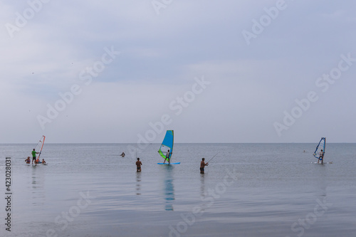 People are windsurfing in the sea. Sports fun on the water