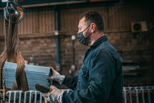 adult man in uniform works in an industry with machinery