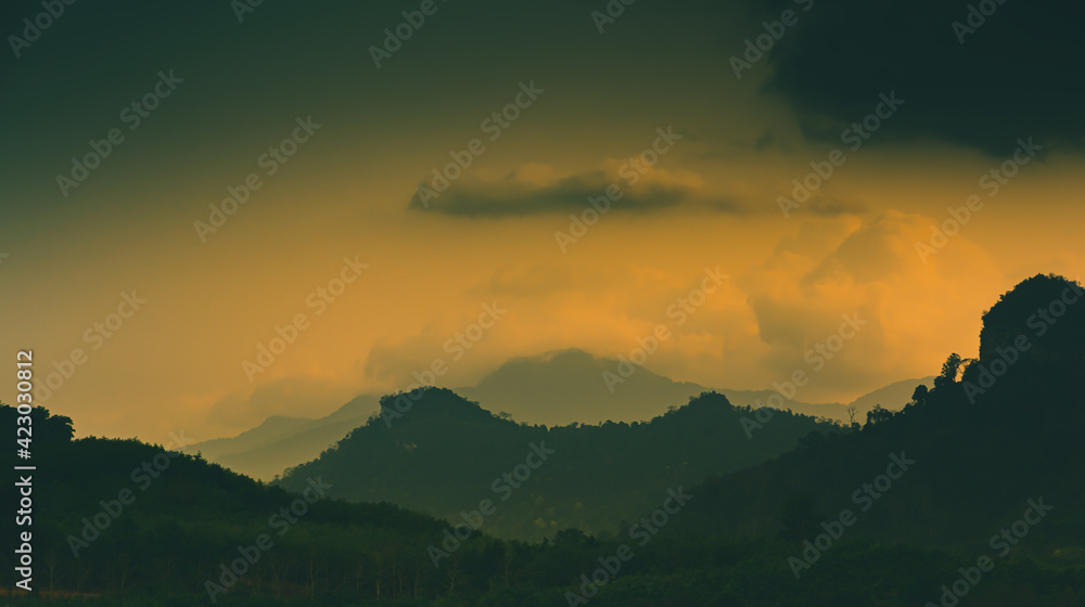 The light of the sun is setting along the mountains and fertile forests at Klong Phawa Yai Reservoir, Kaeng Hang, Chanthaburi, Thailand.