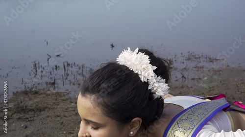 A bharatnatyam dancer displaying a classical bharatnatyam pose in the nature of  Vadatalav lake, Pavagadh. Beautiful indian girl dancer in the posture of Indian classical dance bharatanatyam . photo