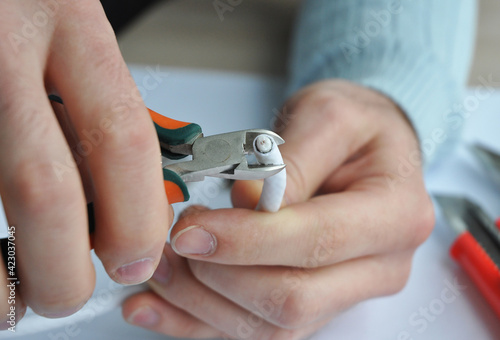 Quadro su tela A man is cutting the coaxial cable for TV using a cable cutter to repair and fix the coax cable