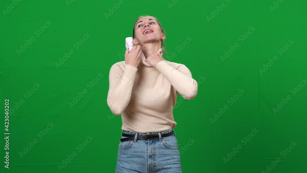 Slim woman putting sock in bra to make breasts bigger. Portrait of funny young Caucasian lady posing at chromakey background. Green screen. Slim woman putting sock in bra to make breasts bigger. Portrait of funny young Caucasian lady posing at chromakey background. Green screen.