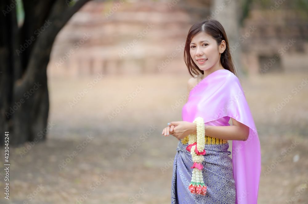 Attractive Thai women in traditional Thai dress hold fresh flower garlands for entering a temple based on the Songkran festival tradition in Thailand