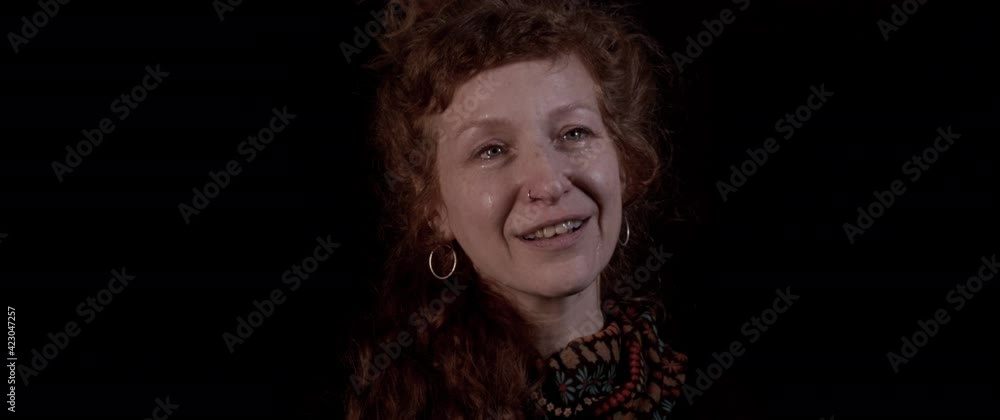 Hopeful woman with red hair smiles in tears Hopeful woman with red hair smiles in tears