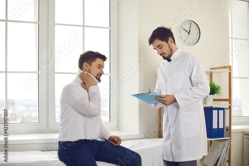 Medical interview  professional help and injury treatment after accident. Male patient with broken neck in cervical collar and doctor at clinic. Traumatologist making prescription notes in clipboard