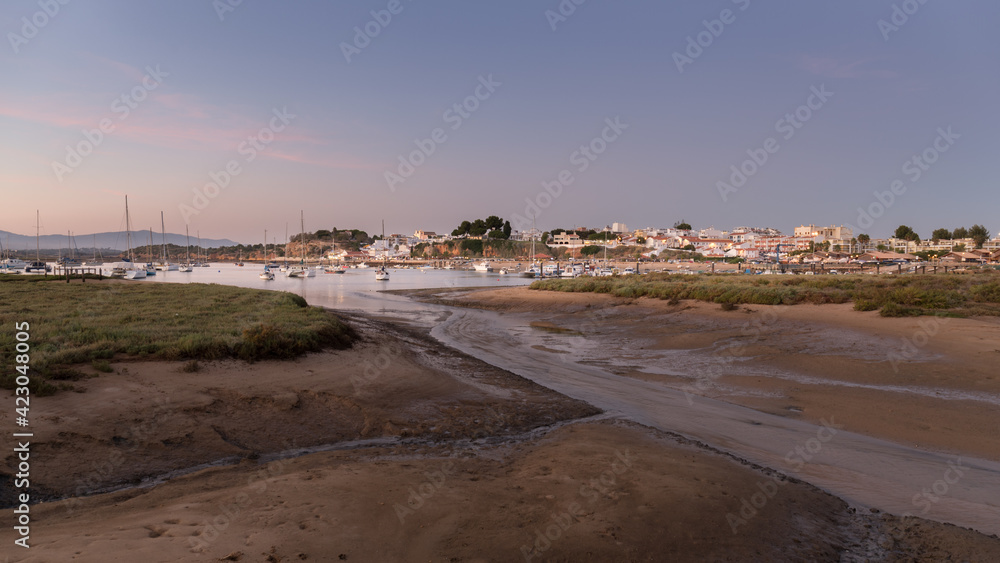 View from the fishing village near the mouth of the river of Alvor with boats, Algarve at sunset