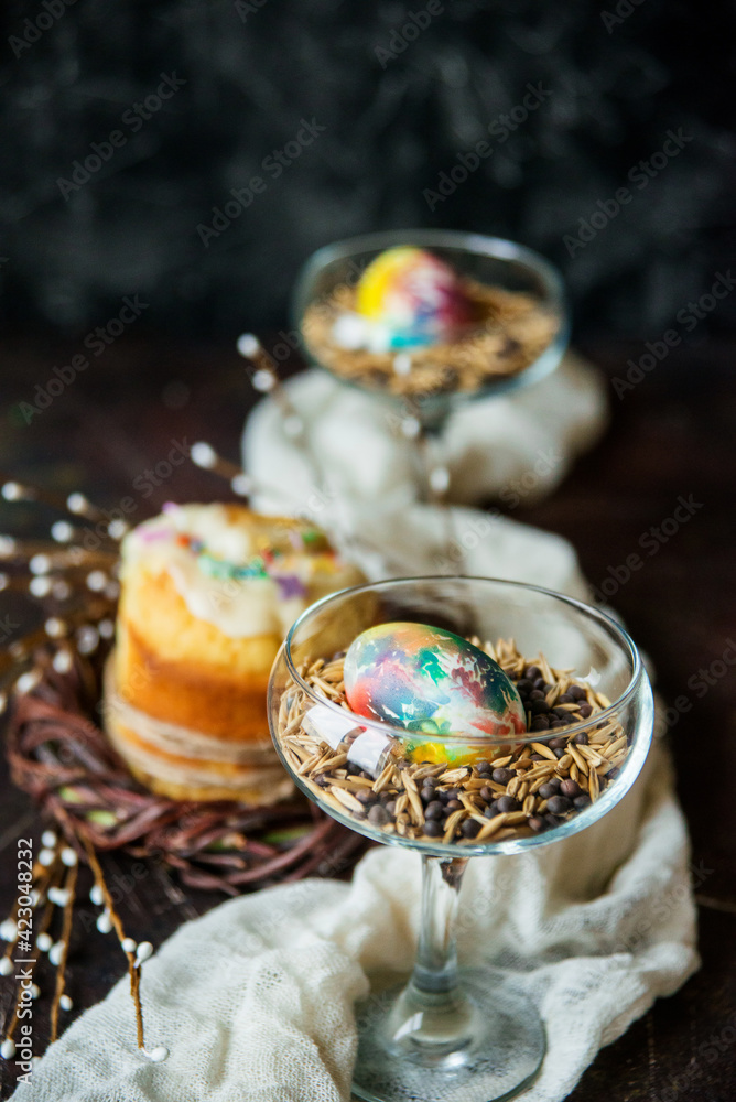 A painted egg lies in a glass with a mixture of seeds and cereals, a symbol of abundance, an Easter composition A painted egg lies in a glass with a mixture of seeds and cereals, a symbol of abundance, an Easter composition