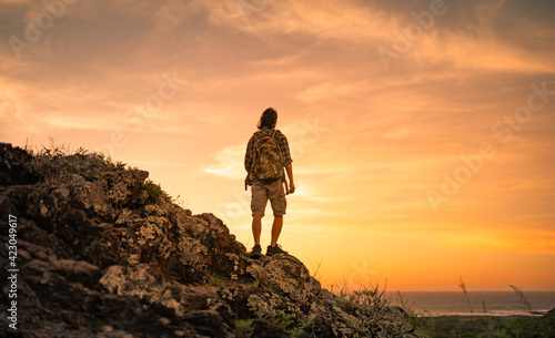 Man hiker onto of a mountain looking at the view. People taking risk, motivation and outdoor adventure concept. 