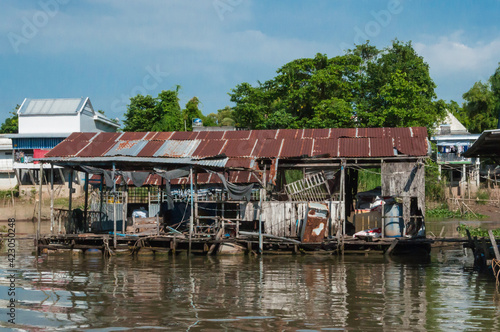 Blick vom Mekong auf den Uferbereich. Dieser ist gesäumt mit typischen Stelzenbauten, gebaut aus Wellblech. 