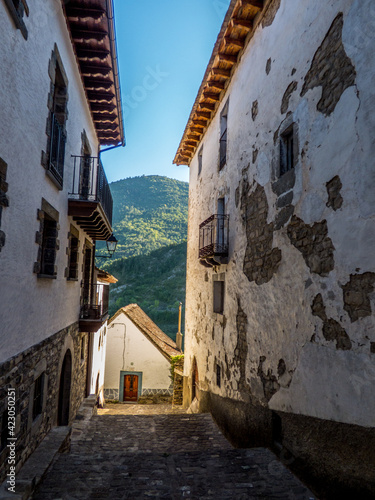 Calles cuyas fachadas combinan la piedra y el encalado en la aldea de montaña de Ansó, España photo